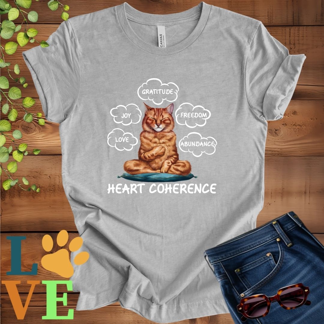 Light grey heather (athletic heather) t-shirt with a meditating Abyssinian cat, surrounded by floating emotion bubbles labelled love, joy, gratitude, freedom, abundance, and 'Heart Coherence' slogan.