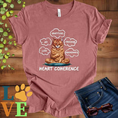 Muted mauve-purple (heather mauve) t-shirt with a meditating Abyssinian cat, surrounded by floating emotion bubbles labelled love, joy, gratitude, freedom, abundance, and 'Heart Coherence' slogan.