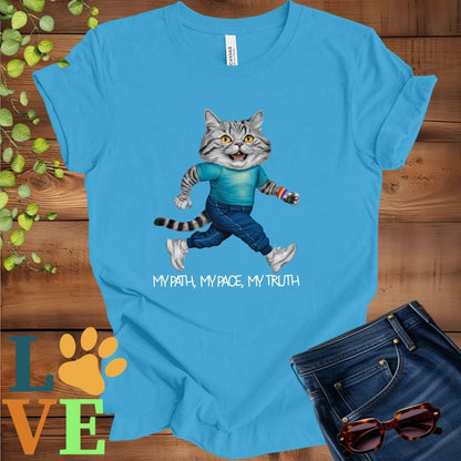 Bright aqua blue t-shirt featuring an anthropomorphic American Shorthair cat in exercise wear walking confidently with the slogan, "My path, my pace, my truth."