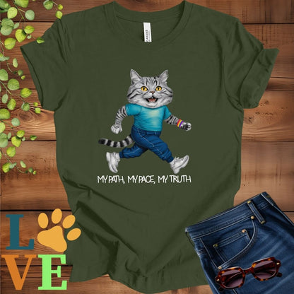 Olive green (military green) t-shirt featuring an anthropomorphic American Shorthair cat in exercise wear walking confidently with the slogan, "My path, my pace, my truth."