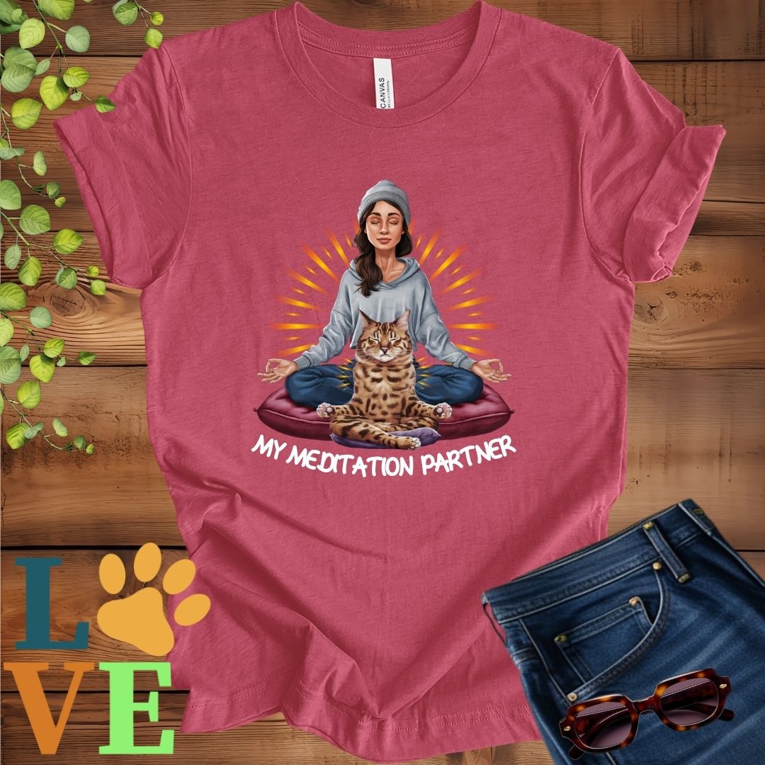 Muted raspberry pink (heather raspberry) t-shirt featuring a woman meditating with her Bengal cat and the slogan "My meditation partner".