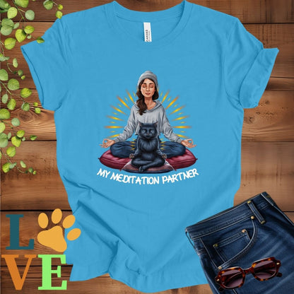 Bright aqua blue t-shirt featuring a woman meditating with her black cat and the slogan "My meditation partner".
