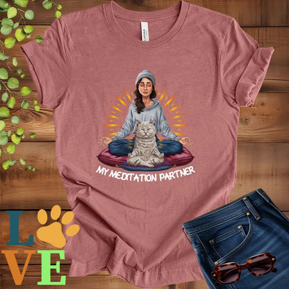 Muted mauve-purple (heather mauve) t-shirt featuring a woman meditating with her British Shorthair cat and the slogan "My meditation partner".