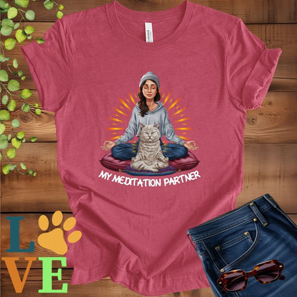 Muted raspberry pink (heather raspberry) t-shirt featuring a woman meditating with her British Shorthair cat and the slogan "My meditation partner".