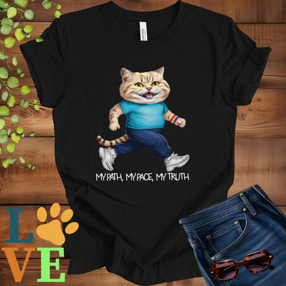 Black t-shirt featuring an anthropomorphic British Shorthair cat in exercise wear walking confidently with the slogan, "My path, my pace, my truth."
