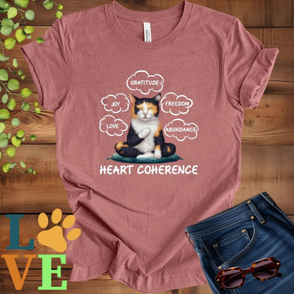 Muted mauve-purple (heather mauve) t-shirt with a meditating calico cat, surrounded by floating emotion bubbles labelled love, joy, gratitude, freedom, abundance, and 'Heart Coherence' slogan.