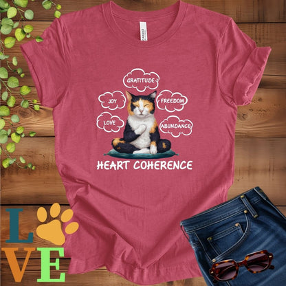 Muted raspberry pink (heather raspberry) t-shirt with a meditating calico cat, surrounded by floating emotion bubbles labelled love, joy, gratitude, freedom, abundance, and 'Heart Coherence' slogan.