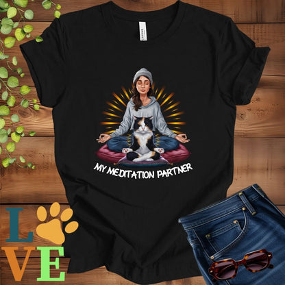 Black t-shirt featuring a woman meditating with her calico cat and the slogan "My meditation partner".