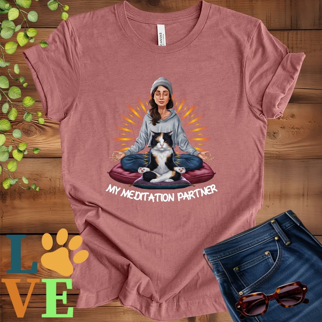 Muted mauve-purple (heather mauve) t-shirt featuring a woman meditating with her calico cat and the slogan "My meditation partner".