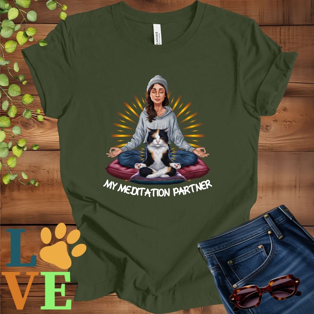 Olive green (military green) t-shirt featuring a woman meditating with her calico cat and the slogan "My meditation partner".