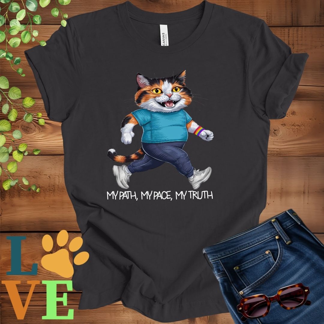 Dark grey heather t-shirt featuring an anthropomorphic calico cat in exercise wear walking confidently with the slogan, "My path, my pace, my truth."
