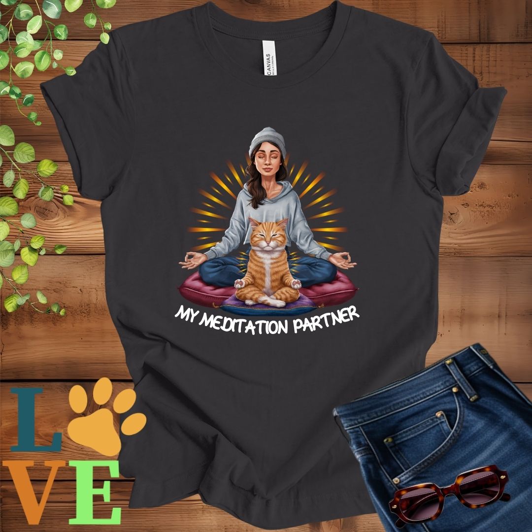 Dark grey heather t-shirt featuring a woman meditating with her ginger cat and the slogan "My meditation partner".
