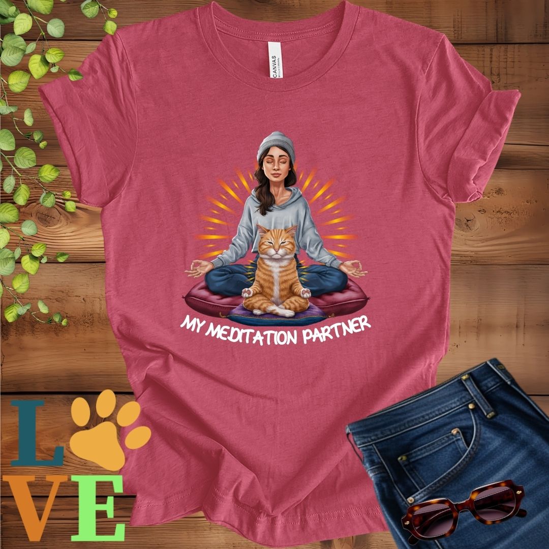 Muted raspberry pink (heather raspberry) t-shirt featuring a woman meditating with her ginger cat and the slogan "My meditation partner".