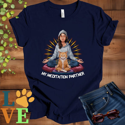 Navy blue t-shirt featuring a woman meditating with her ginger cat and the slogan "My meditation partner".