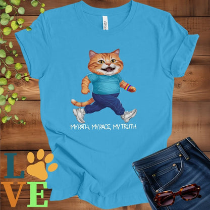 Bright aqua blue t-shirt featuring an anthropomorphic ginger cat in exercise wear walking confidently with the slogan, "My path, my pace, my truth."
