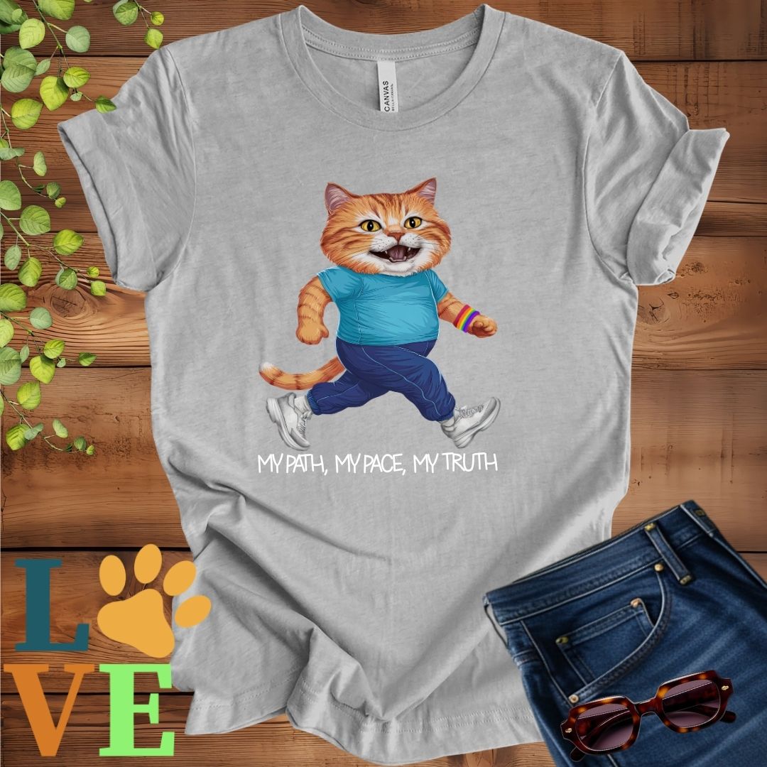 Light grey heather (athletic heather) t-shirt featuring an anthropomorphic ginger cat in exercise wear walking confidently with the slogan, "My path, my pace, my truth."
