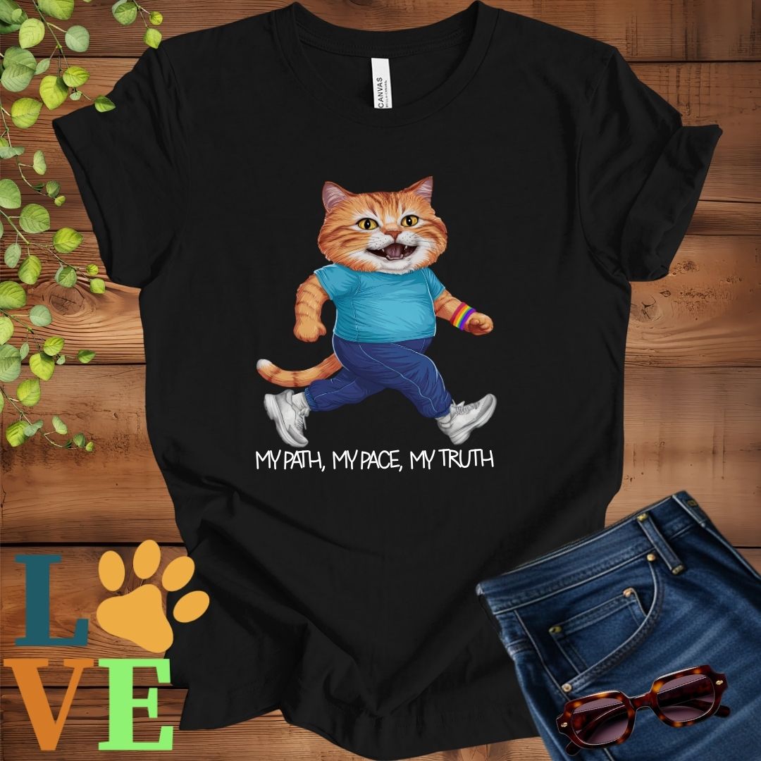 Black t-shirt featuring an anthropomorphic ginger cat in exercise wear walking confidently with the slogan, "My path, my pace, my truth."
