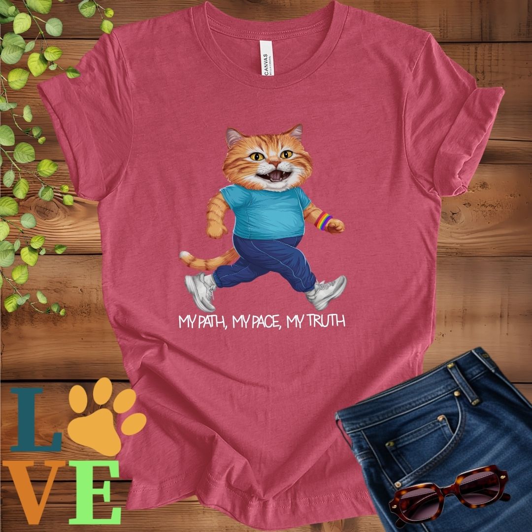 Muted raspberry pink (heather raspberry) t-shirt featuring an anthropomorphic ginger cat in exercise wear walking confidently with the slogan, "My path, my pace, my truth."
