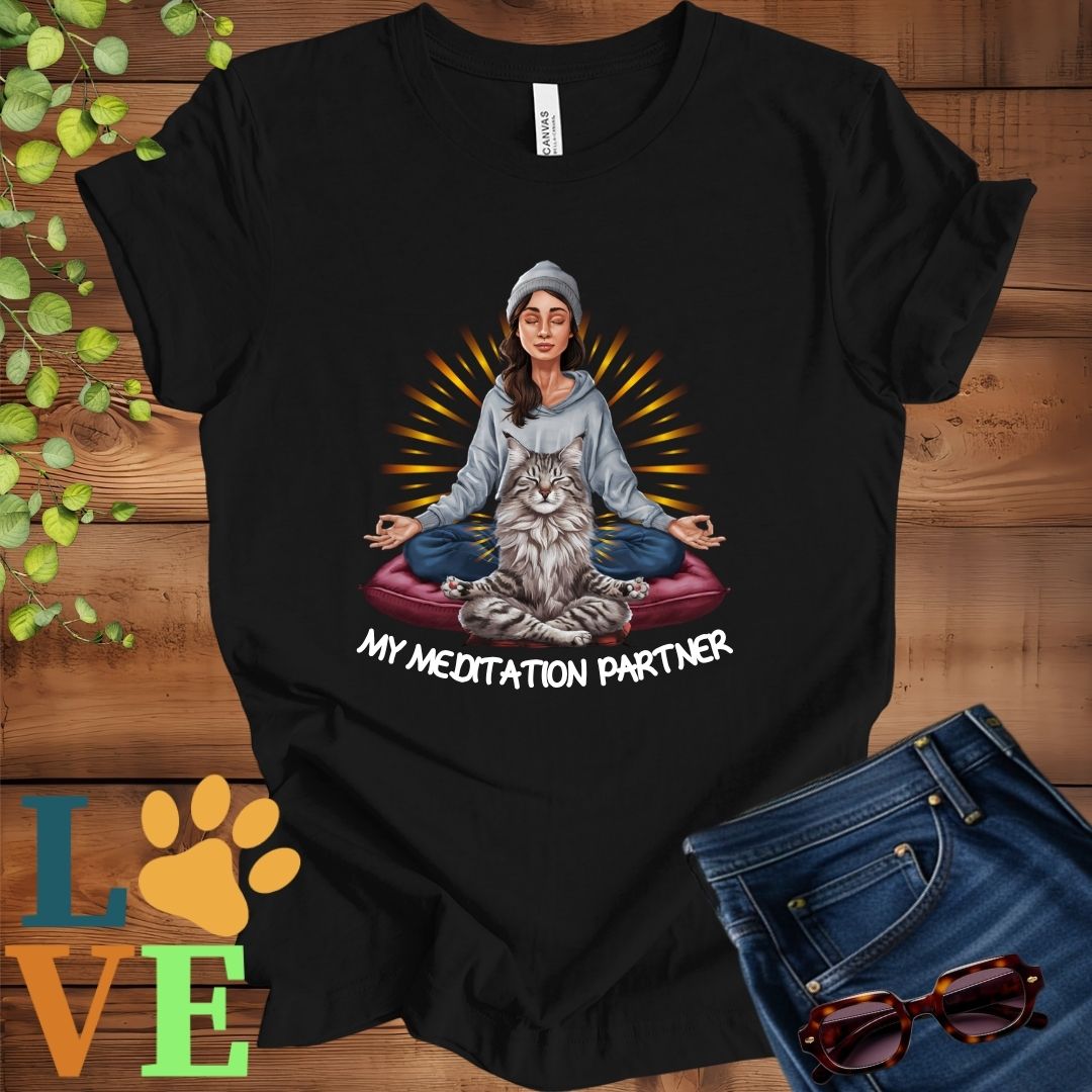 Black t-shirt featuring a woman meditating with her Maine Coon cat and the slogan "My meditation partner".