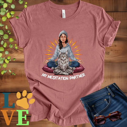 Muted mauve-purple (heather mauve) t-shirt featuring a woman meditating with her Maine Coon cat and the slogan "My meditation partner".