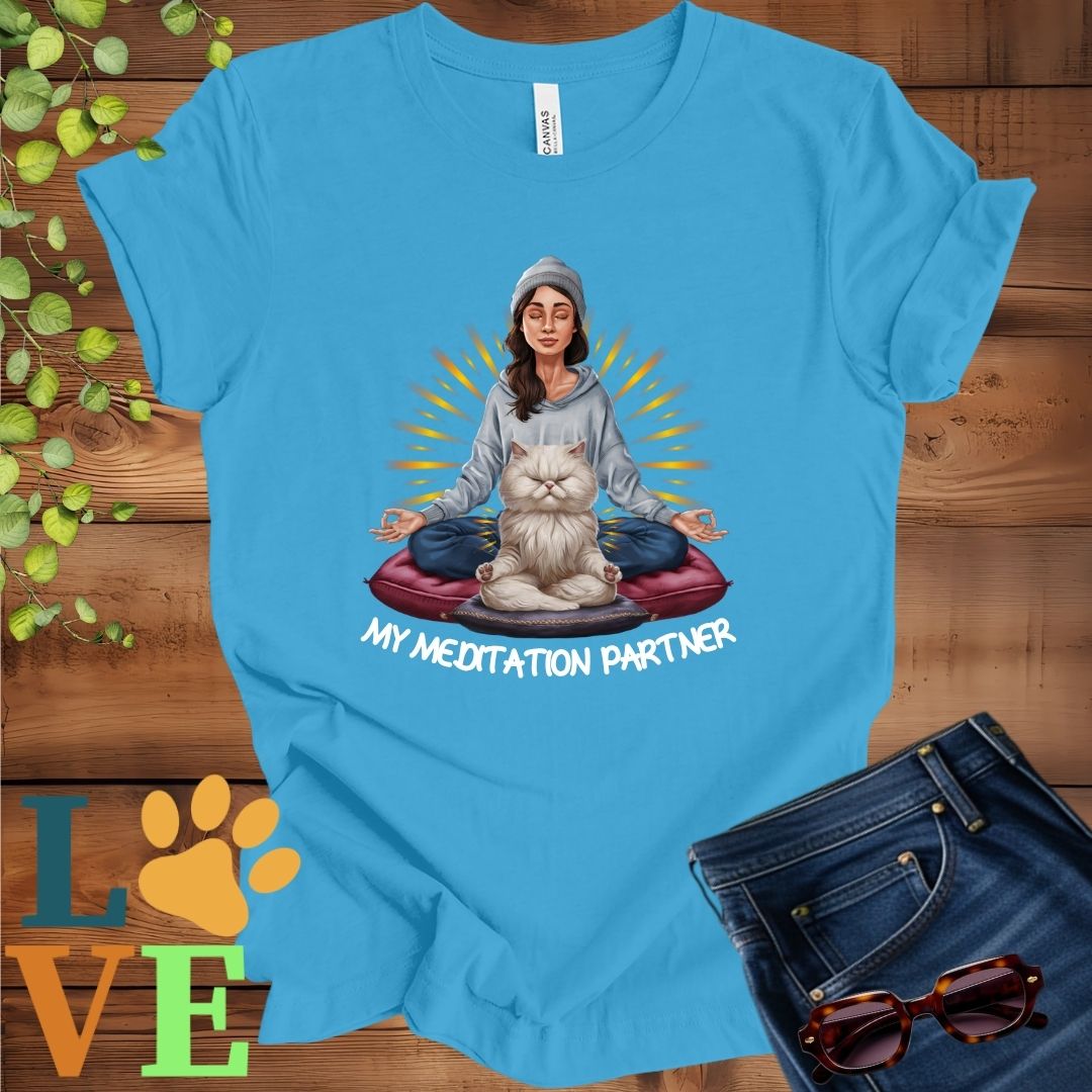 Bright aqua blue t-shirt featuring a woman meditating with her Persian cat and the slogan "My meditation partner".