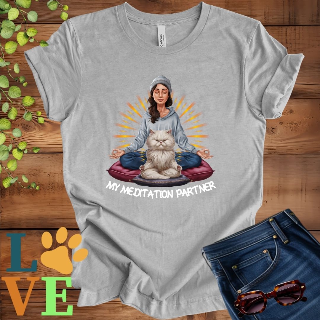 Light grey heather (athletic heather)t-shirt featuring a woman meditating with her Persian cat and the slogan "My meditation partner".