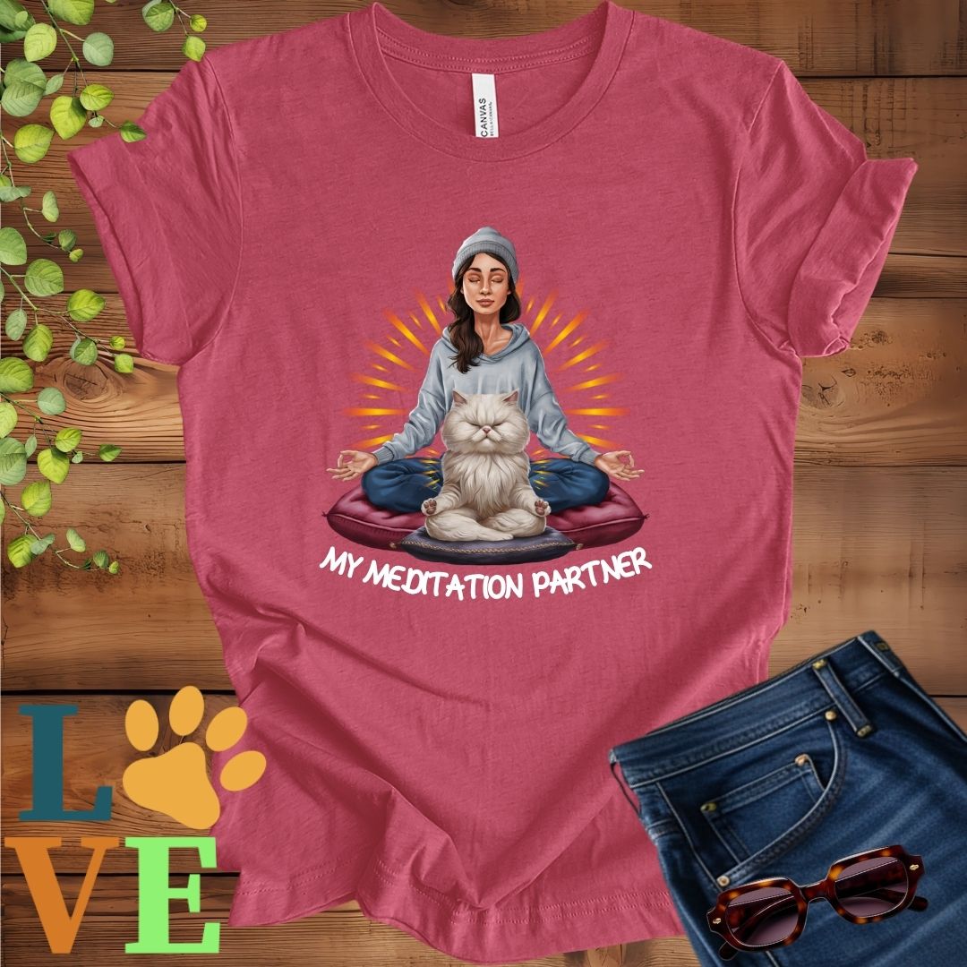 Muted raspberry pink (heather raspberry) t-shirt featuring a woman meditating with her Persian cat and the slogan "My meditation partner".