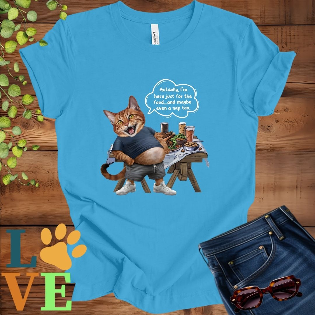 Bright aqua blue t-shirt with an anthropomorphic Abyssinian cat, standing in front of a table with food and drinks, showing its pot belly and humorous speech bubble message.