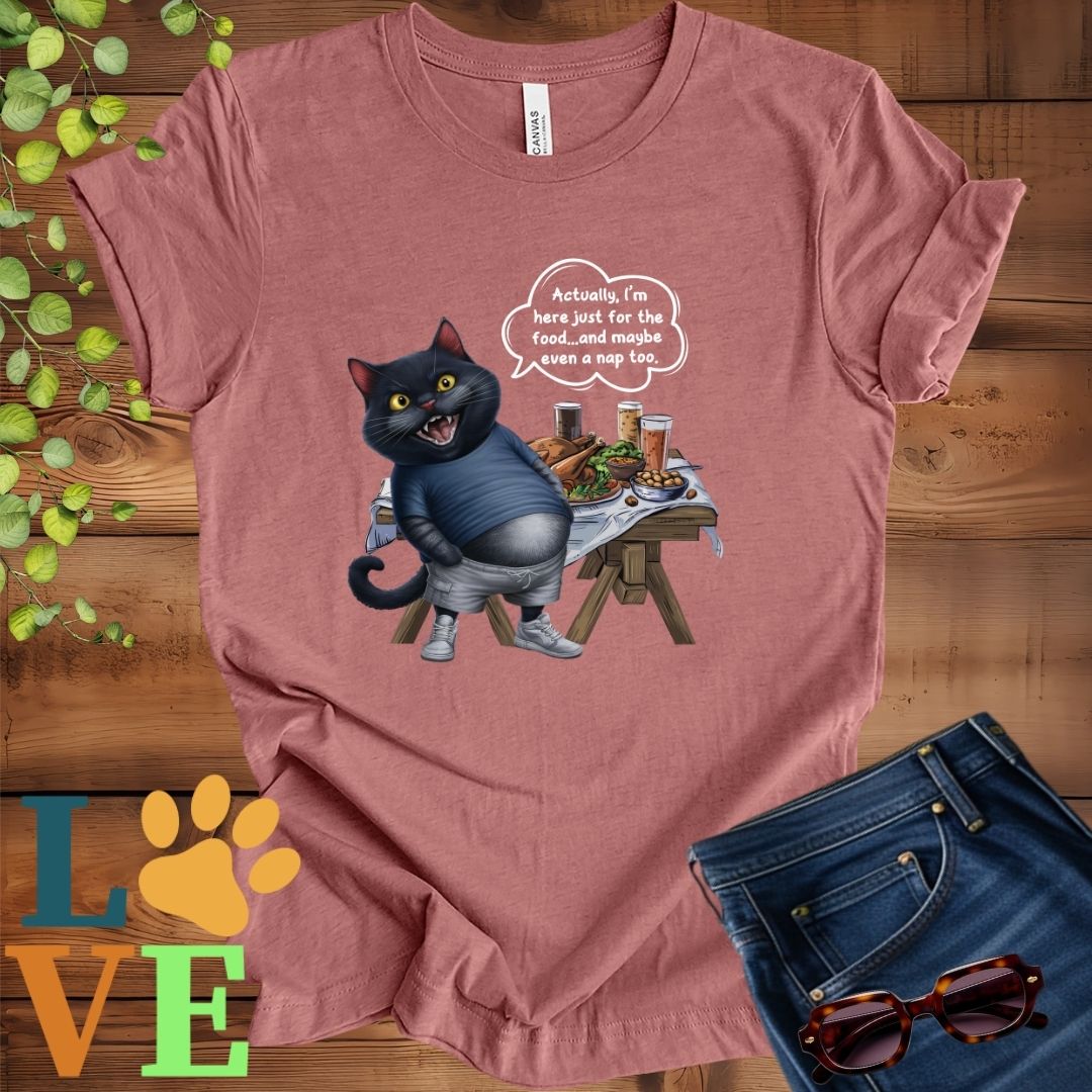 Muted mauve-purple (heather mauve) t-shirt with an anthropomorphic black cat, standing in front of a table with food and drinks, showing its pot belly and humorous speech bubble message.