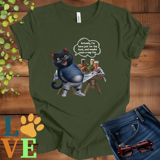 Olive green (military green) t-shirt with an anthropomorphic black cat, standing in front of a table with food and drinks, showing its pot belly and humorous speech bubble message.