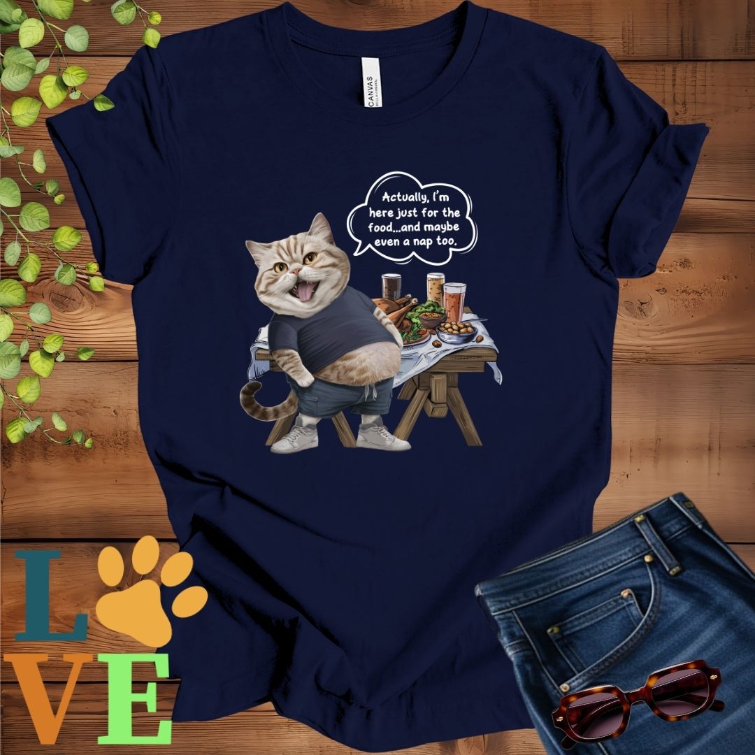 Navy blue t-shirt with an anthropomorphic British Shorthair cat, standing in front of a table with food and drinks, showing its pot belly and humorous speech bubble message.