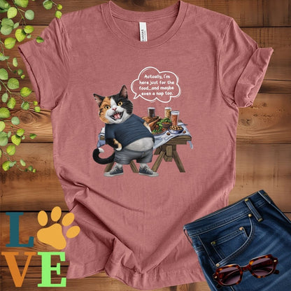 Muted mauve-purple (heather mauve) t-shirt with an anthropomorphic calico cat, standing in front of a table with food and drinks, showing its pot belly and humorous speech bubble message.