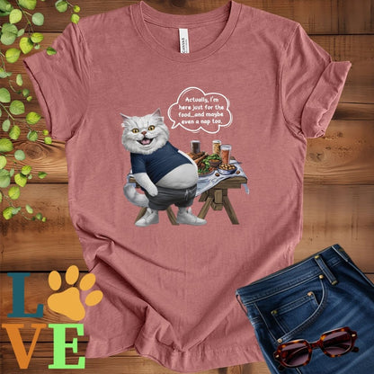 Muted mauve-purple (heather mauve) t-shirt with an anthropomorphic Persian cat, standing in front of a table with food and drinks, showing its pot belly and humorous speech bubble message.