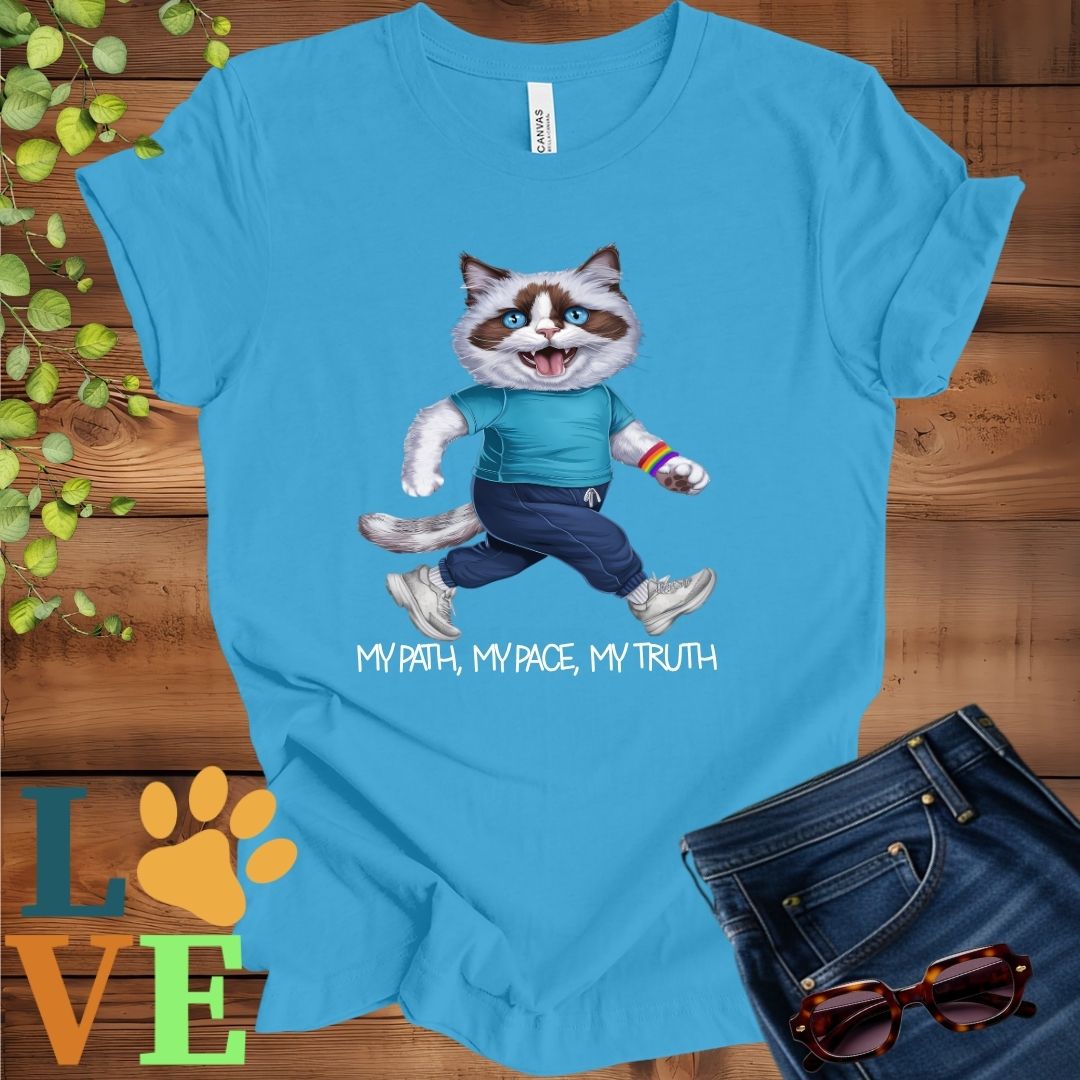 Bright aqua blue t-shirt featuring an anthropomorphic Ragdoll cat in exercise wear walking confidently with the slogan, "My path, my pace, my truth."
