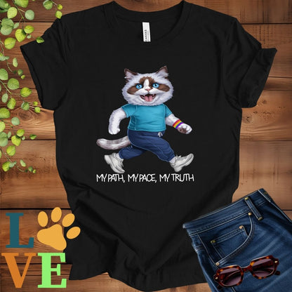 Black t-shirt featuring an anthropomorphic Ragdoll cat in exercise wear walking confidently with the slogan, "My path, my pace, my truth."
