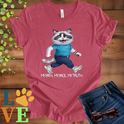 Muted raspberry pink (heather raspberry) t-shirt featuring an anthropomorphic Ragdoll cat in exercise wear walking confidently with the slogan, "My path, my pace, my truth."
