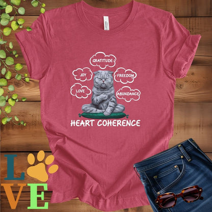 Muted raspberry pink (heather raspberry) t-shirt with a meditating Scottish Fold cat, surrounded by floating emotion bubbles labelled love, joy, gratitude, freedom, abundance, and 'Heart Coherence' slogan.