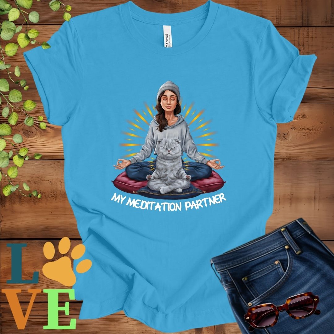Bright aqua blue t-shirt featuring a woman meditating with her Scottish Fold cat and the slogan "My meditation partner".