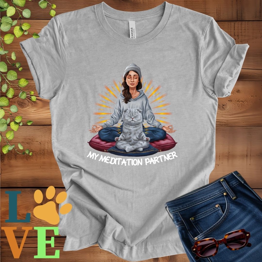 Light grey heather (athletic heather) t-shirt featuring a woman meditating with her Scottish Fold cat and the slogan "My meditation partner".