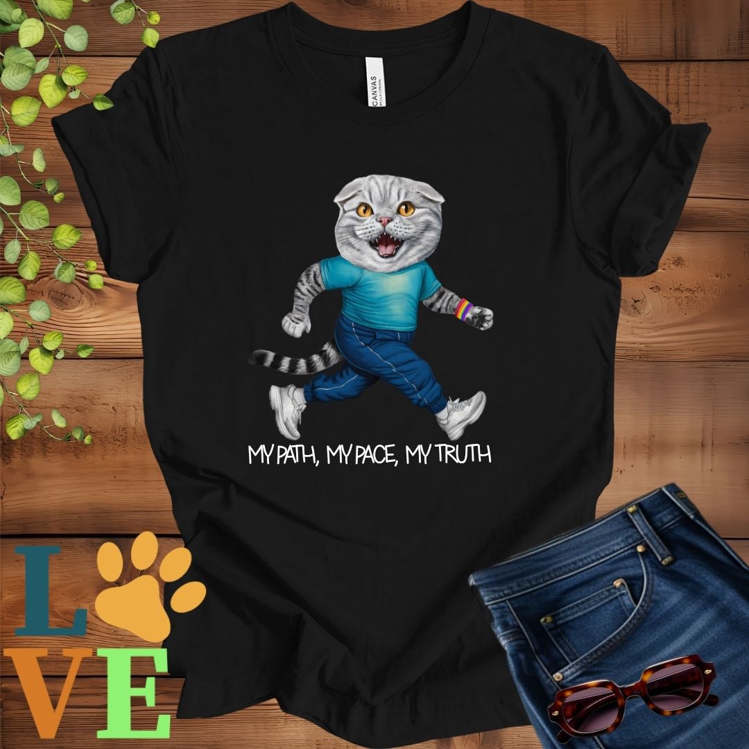 Black t-shirt featuring an anthropomorphic Scottish Fold cat in exercise wear walking confidently with the slogan, "My path, my pace, my truth."