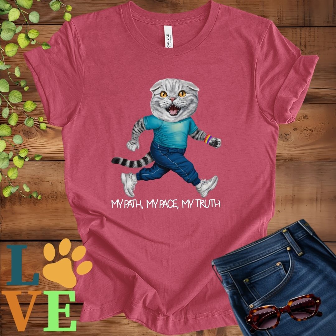 Muted raspberry pink (heather raspberry) t-shirt featuring an anthropomorphic Scottish Fold cat in exercise wear walking confidently with the slogan, "My path, my pace, my truth."