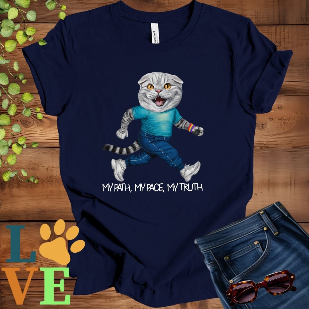 Navy blue t-shirt featuring an anthropomorphic Scottish Fold cat in exercise wear walking confidently with the slogan, "My path, my pace, my truth."