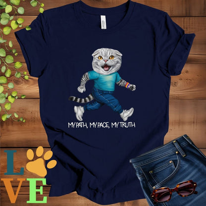Navy blue t-shirt featuring an anthropomorphic Scottish Fold cat in exercise wear walking confidently with the slogan, "My path, my pace, my truth."