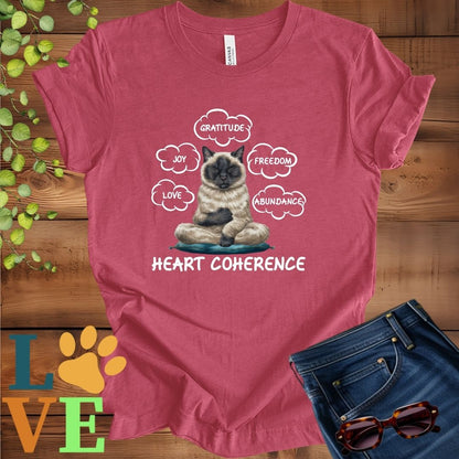 Muted raspberry pink (heather raspberry) t-shirt with a meditating Siamese cat, surrounded by floating emotion bubbles labelled love, joy, gratitude, freedom, abundance, and 'Heart Coherence' slogan.