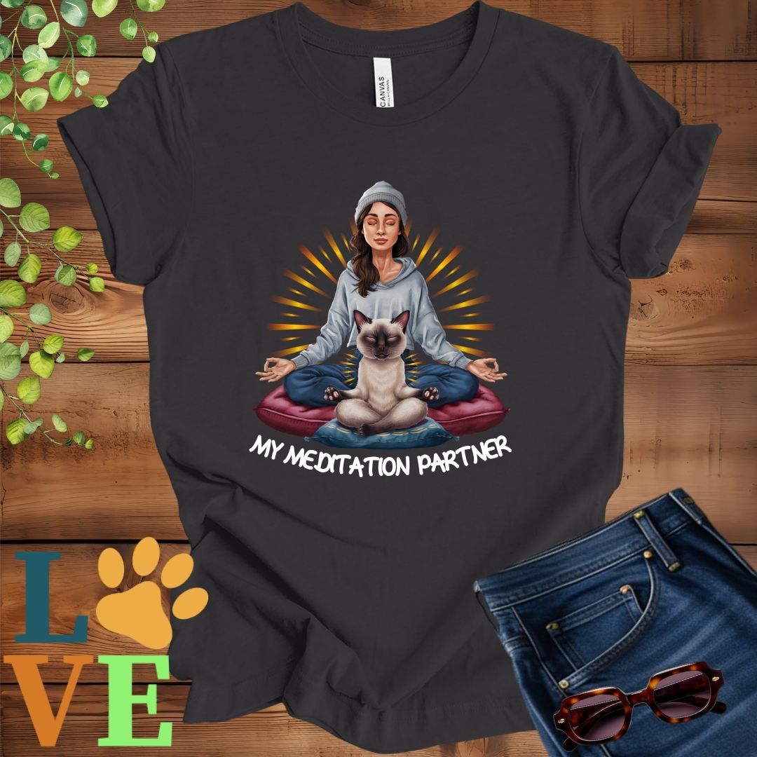 Dark grey heather t-shirt featuring a woman meditating with her Siamese cat and the slogan "My meditation partner".
