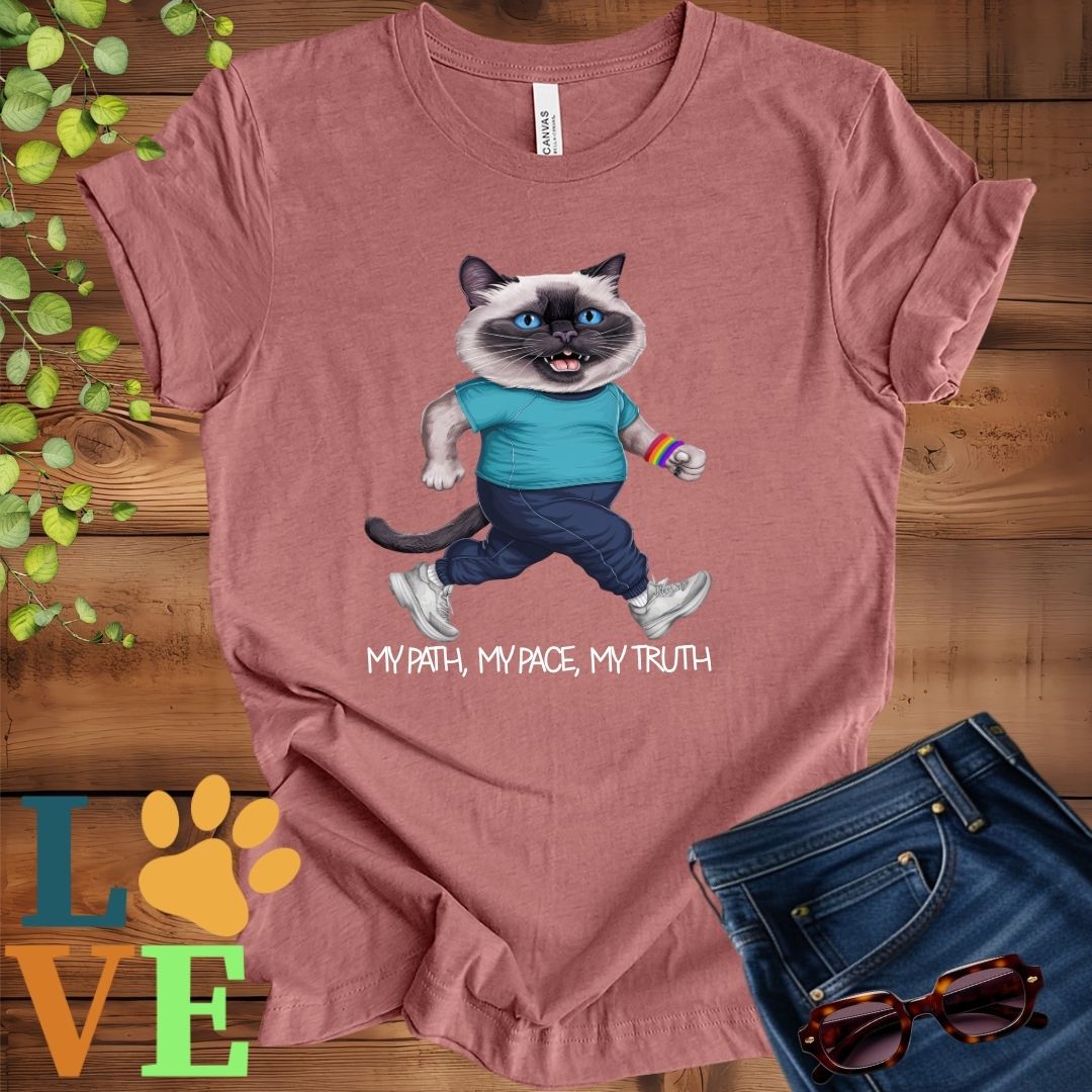 Muted mauve-purple (heather mauve) t-shirt featuring an anthropomorphic Siamese cat in exercise wear walking confidently with the slogan, "My path, my pace, my truth."
