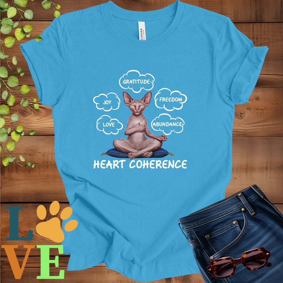 Bright aqua blue t-shirt with a meditating Sphynx cat, surrounded by floating emotion bubbles labelled love, joy, gratitude, freedom, abundance, and 'Heart Coherence' slogan.