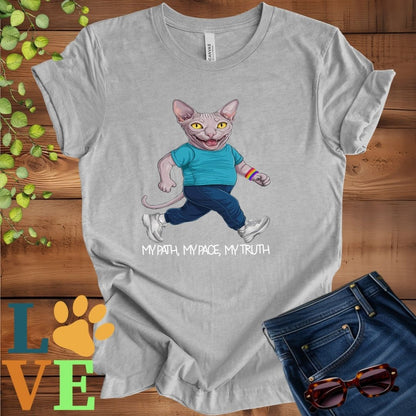 Light grey heather (athletic heather) t-shirt featuring an anthropomorphic Sphynx cat in exercise wear walking confidently with the slogan, "My path, my pace, my truth."
