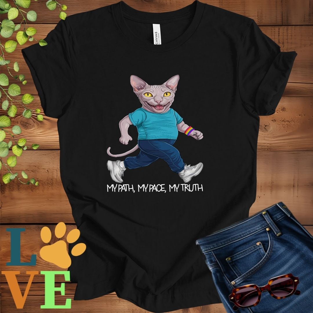 Black t-shirt featuring an anthropomorphic Sphynx cat in exercise wear walking confidently with the slogan, "My path, my pace, my truth."

