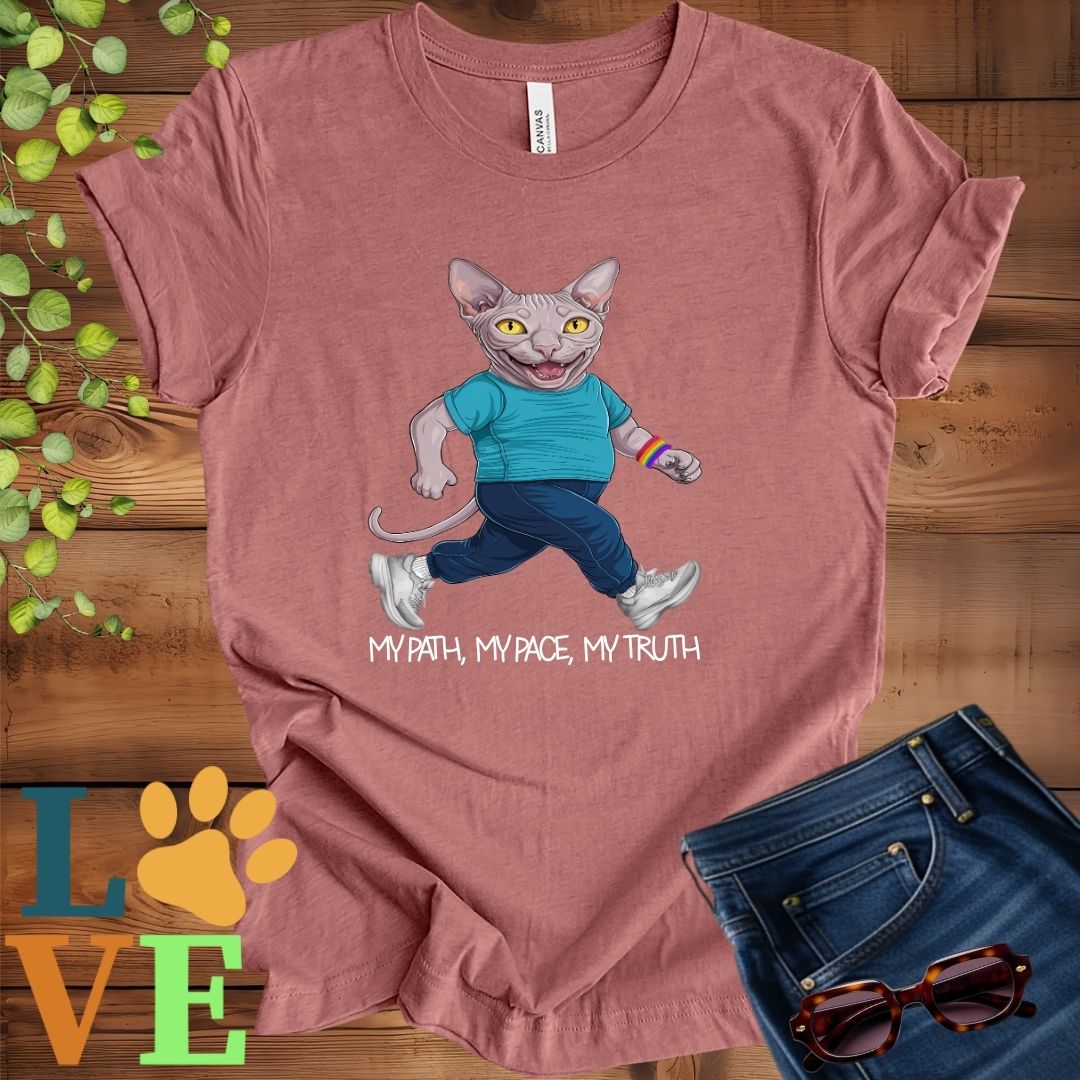 Muted mauve-purple (heather mauve) t-shirt featuring an anthropomorphic Sphynx cat in exercise wear walking confidently with the slogan, "My path, my pace, my truth."
